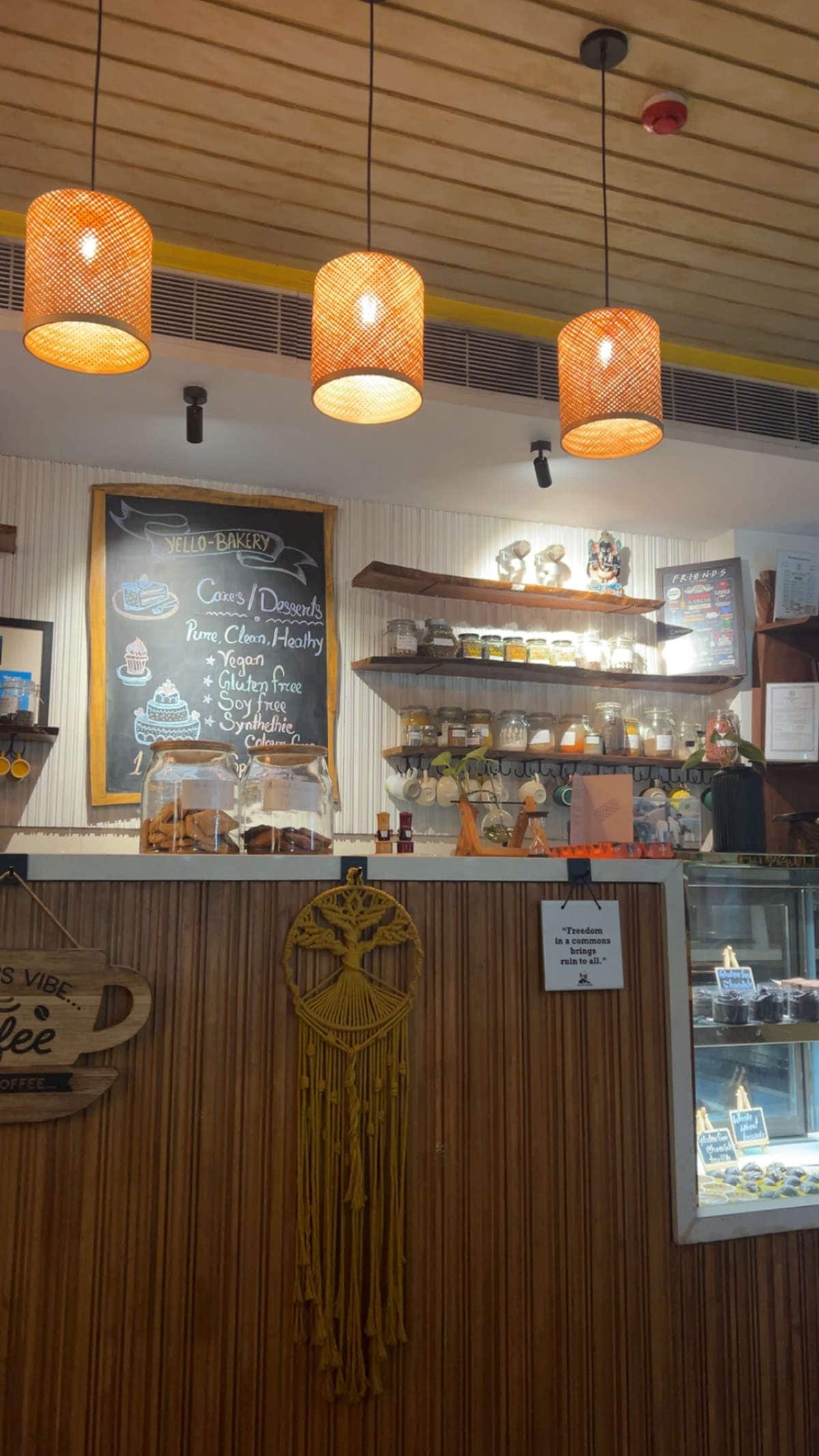 Bakery counter with chalkboard menu and dessert display at Yellolife Cafe